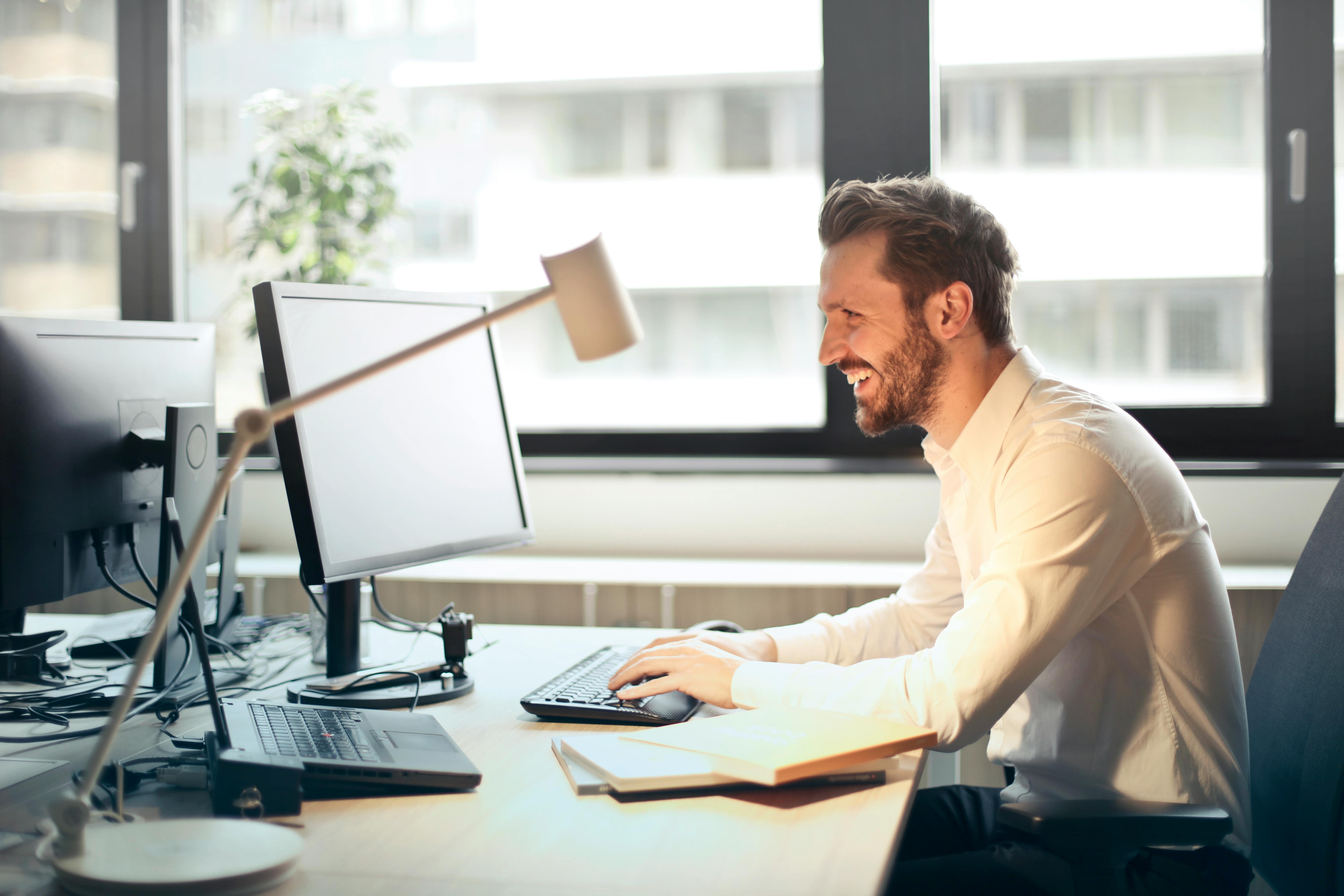 happy man with healthy boundaries at his work desk